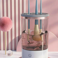 Make Up Brush Cleaner electric device with USB recharge, automatic deep cleaning for cosmetic brushes in a clear water tank.